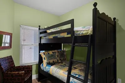 a bedroom with two bunk beds and a chair at Majestic Beach Towers 2-1905 in Panama City Beach
