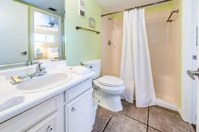 a bathroom with a toilet and a sink and a shower at Moonspinner 211B - PCB East in Panama City Beach