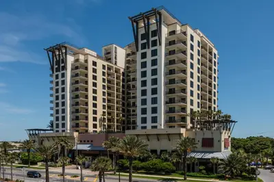 two tall buildings with palm trees in front of a street at Origin at Seahaven 825 in Panama City Beach