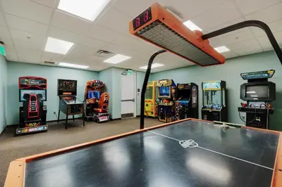a room with a ping pong table and arcade games at Origin at Seahaven 825 in Panama City Beach