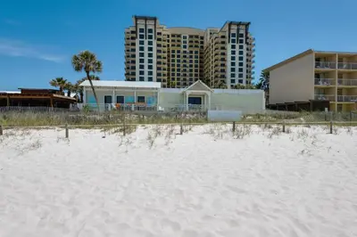 a house on the beach with buildings in the background at Origin at Seahaven 825 in Panama City Beach