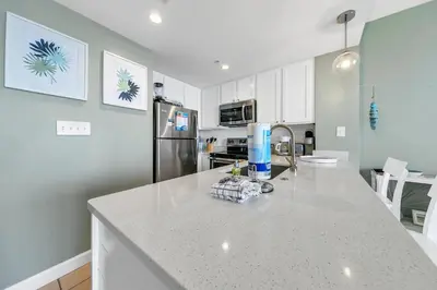 a kitchen with a white counter top and a refrigerator at Seychelles 1504 in Panama City Beach