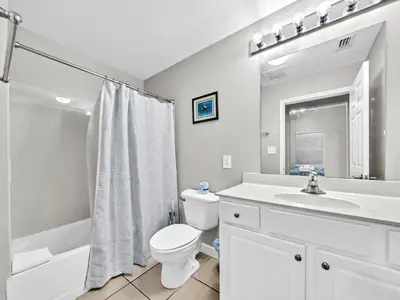 a white bathroom with a toilet and a sink at Seychelles 207 in Panama City Beach