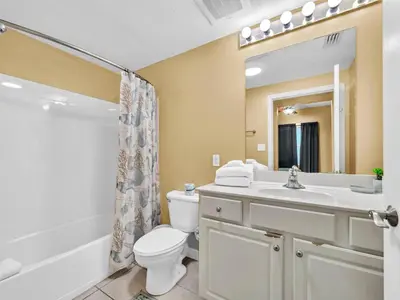 a bathroom with a toilet and a sink and a shower at Seychelles 907 in Panama City Beach