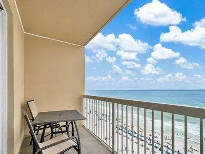 a balcony with a table and chairs and the ocean at Seychelles 907 in Panama City Beach