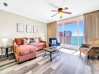 a living room with a couch and chairs and a balcony at Shores of Panama 2112 in Panama City Beach