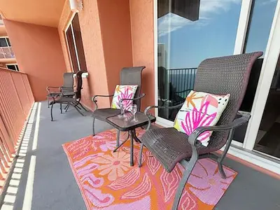 a patio with chairs and tables on a balcony at Shores of Panama 2112 in Panama City Beach