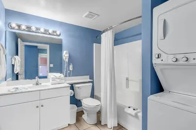 a blue bathroom with a toilet and a sink at Shores of Panama 2112 in Panama City Beach