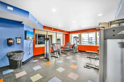 a gym with several treadmills and chairs in a room at Shores of Panama 2112 in Panama City Beach