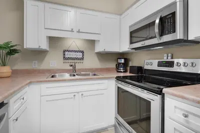 a white kitchen with white cabinets and a sink at Southwind I-9 in Panama City Beach