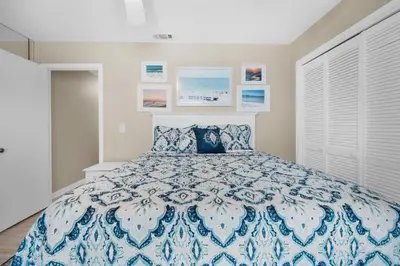a bedroom with a bed with a blue and white bedspread at Southwind I-9 in Panama City Beach