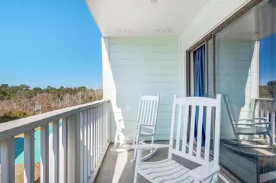 two rocking chairs on a balcony with a view of the ocean at Southwind I-9 in Panama City Beach