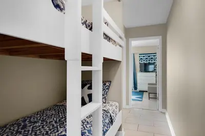 a small bedroom with a bunk bed and a staircase at Southwind I-9 in Panama City Beach