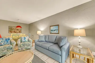 a living room with a blue couch and a chair at Sugar Beach C-2 in Panama City Beach
