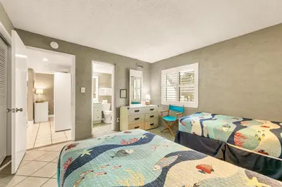 a bedroom with two beds and a desk in it at Sugar Beach C-2 in Panama City Beach