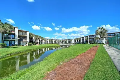 a canal in front of a apartment complex with palm trees at Sugar Beach C-2 in Panama City Beach