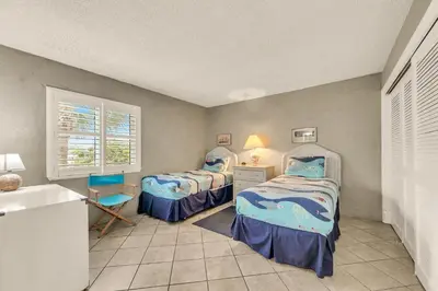 a bedroom with two beds and a desk and a window at Sugar Beach C-2 in Panama City Beach
