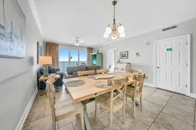 a dining room and living room with a table and chairs at Twin Palms 804 in Panama City Beach