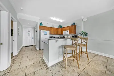 a kitchen with white appliances and wooden cabinets at Twin Palms 804 in Panama City Beach
