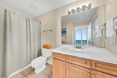 a bathroom with a sink and a toilet and a window at Twin Palms 804 in Panama City Beach