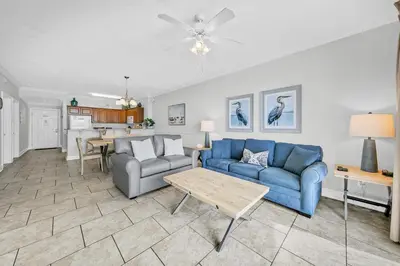 a living room with a blue couch and a table at Twin Palms 804 in Panama City Beach