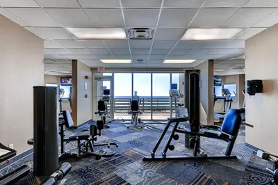 a gym with chairs and a view of the ocean at Tidewater Beach Resort by Panhandle Getaways in Panama City Beach