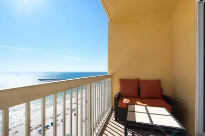 a balcony with a couch and the beach at Calypso Resort Tower 1 Unit 1606 (3/2) in Panama City Beach