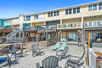 a building with chairs and tables in front of it at Beachside West Townhome in Panama City Beach