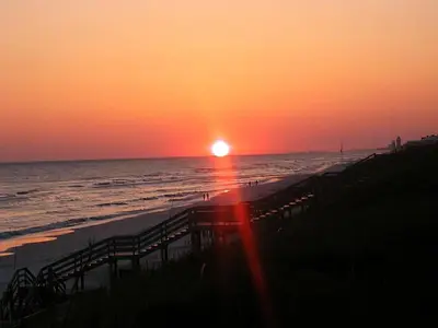 a sunset on the beach with the sun setting at Ramsgate 3 in Watersound Beach