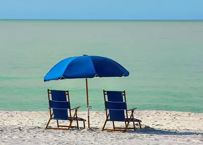 two chairs and an umbrella on a beach at Ramsgate 3 in Watersound Beach
