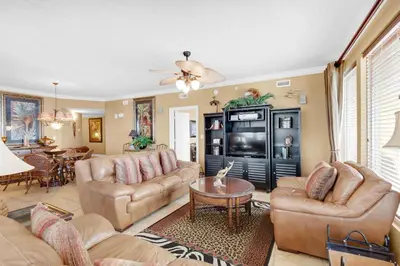 a living room with couches and a tv at Treasure Island 2212 in Panama City Beach