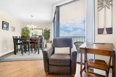 a living room with a chair and a table at Aquavista 304W in Panama City Beach