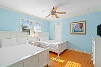 a bedroom with two beds and a ceiling fan at La Valencia Villas in Rosemary Beach
