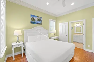 a bedroom with a white bed and two night stands at La Valencia Villas in Rosemary Beach