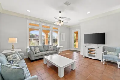 a living room with a couch and a tv at La Valencia Villas in Rosemary Beach