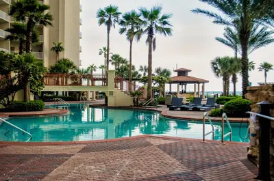a swimming pool at a resort with palm trees at Shores of Panama Resort in Panama City Beach