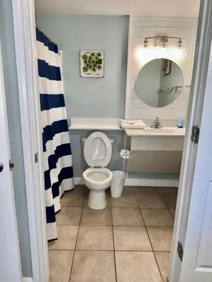a bathroom with a toilet and a sink and a mirror at Shores of Panama Resort in Panama City Beach