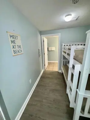 a small room with bunk beds and a hallway at Shores of Panama Resort in Panama City Beach