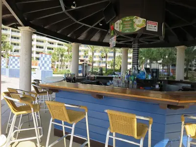 a bar with yellow chairs and a counter at Shores of Panama Resort in Panama City Beach