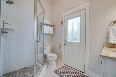 a bathroom with a toilet and a glass shower door at 30A Beach House - Walking on Sunshine in Inlet Beach