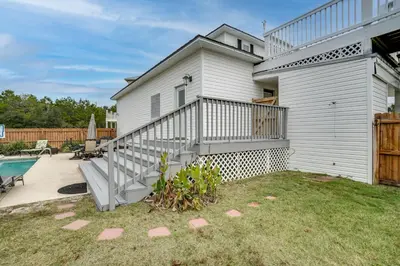 a white house with a staircase next to a yard at 30A Beach House - Walking on Sunshine in Inlet Beach