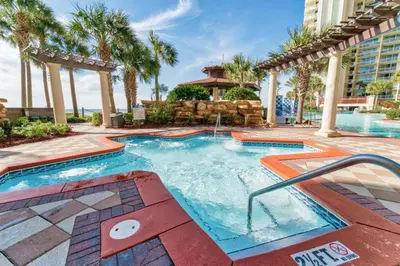 a swimming pool in a resort with palm trees at Shores of Panama by Panhandle Getaways in Panama City Beach