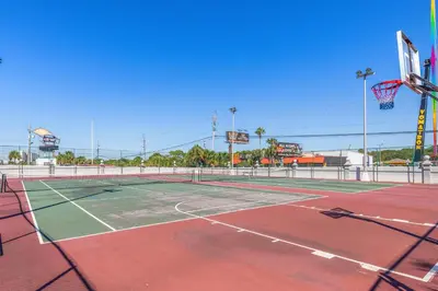 a tennis court with a basketball hoop at The Summit Beach Resort By Panhandle Getaways in Panama City Beach
