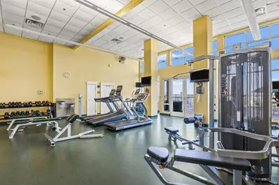 a gym with several treadmills and cardio machines at Grand Panama Beach Resort by Panhandle Getaways in Panama City Beach