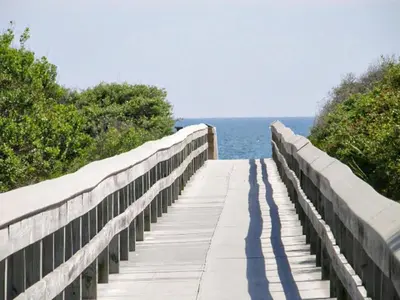 a wooden boardwalk leading to the water on the beach at Blue Sky Bungalow 156 in Seagrove Beach