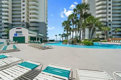 a swimming pool with lounge chairs in a resort at Long Beach Resort by Panhandle Getaways in Panama City Beach
