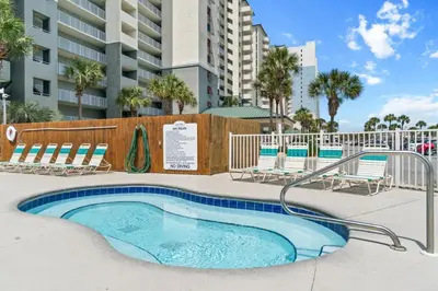 a swimming pool with lounge chairs and a building at Long Beach Resort by Panhandle Getaways in Panama City Beach