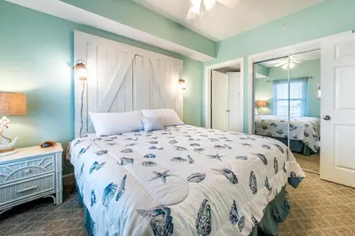 a bedroom with a large bed and a mirror at Majestic Beach Towers 2-603 in Panama City Beach