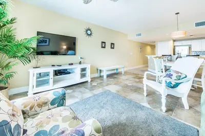 a living room with a couch and chairs and a tv at Majestic Beach Towers 2-603 in Panama City Beach