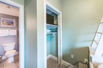 a small bathroom with a toilet and a television at Majestic Beach Towers 2-603 in Panama City Beach